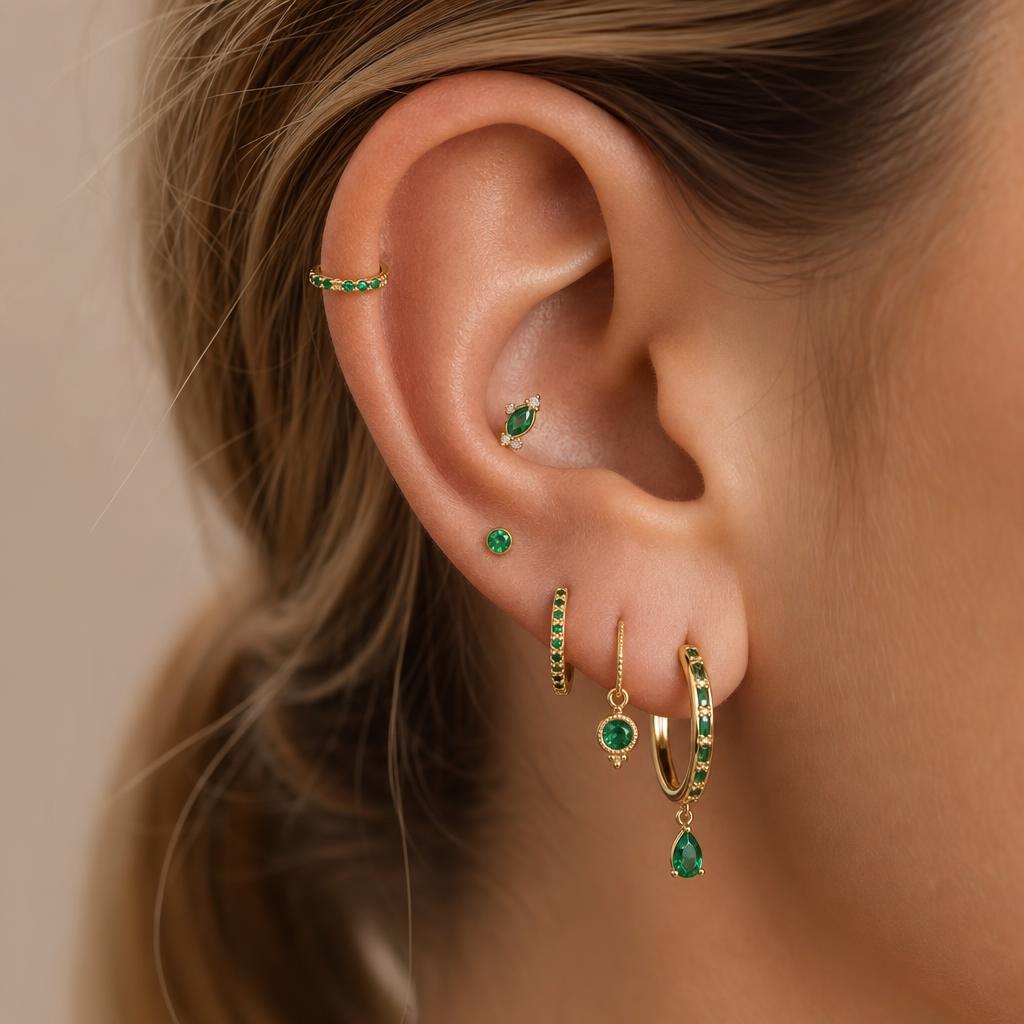 A curated stack of earrings styled on a real ear